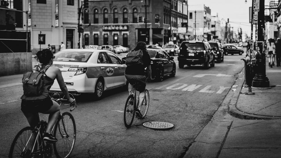 Free Image of Man Riding Bike Down Street Next to Traffic 