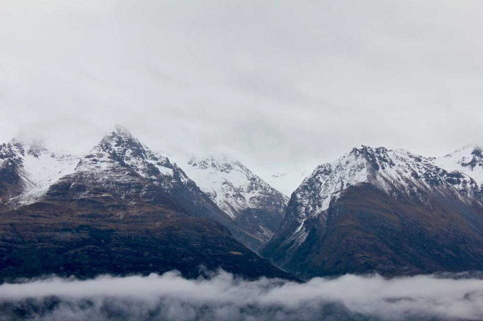 Free Image of Snow-Covered Mountains Shrouded in Clouds 