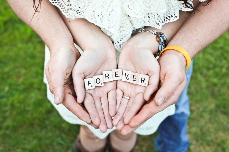 Free Image of Two People Holding Hands With Forever Spelled 
