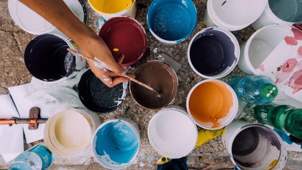 Free Image of Group of People Standing Around Buckets of Paint 