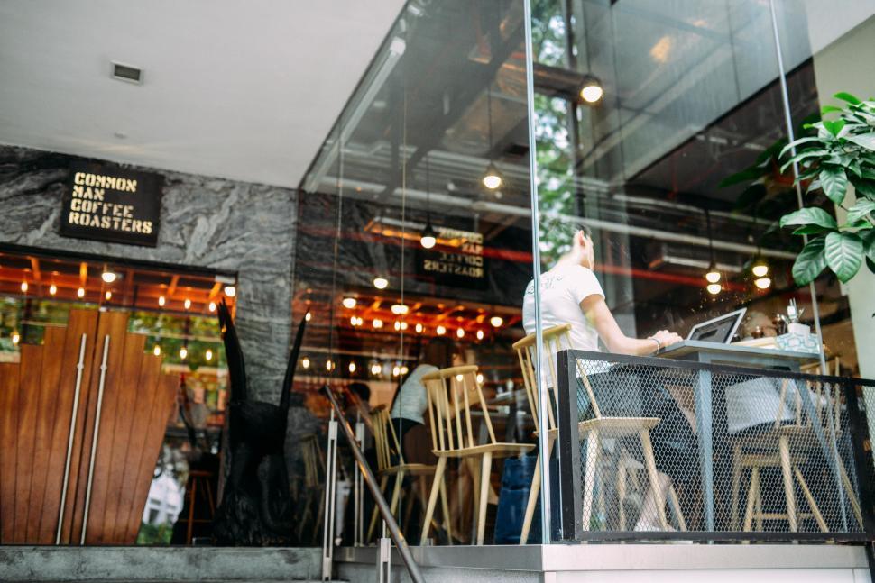 Free Image of Man Sitting at Table Outside Restaurant 