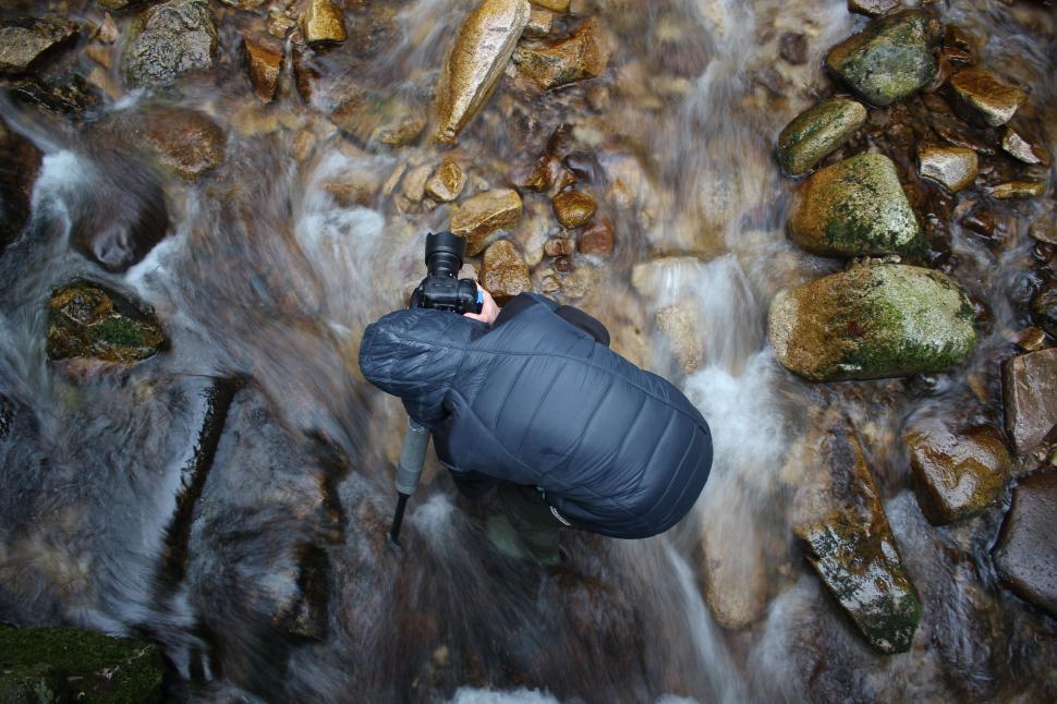 Free Image of Person Standing in Stream With Camera 