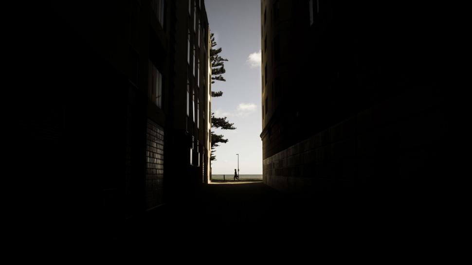 Free Image of Dark Alleyway With Clock on Wall 