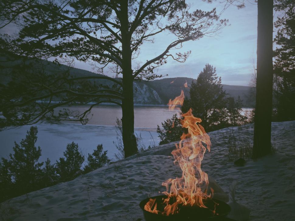 Free Image of Campfire Burning in Snow by Lake 