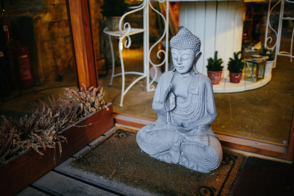 Free Image of Buddha Statue Sitting in Front of a Door 
