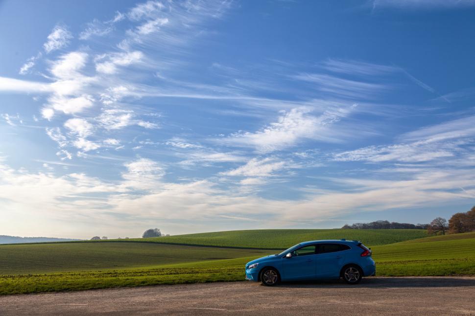 Free Image of Small Blue Car Parked on Dirt Road 