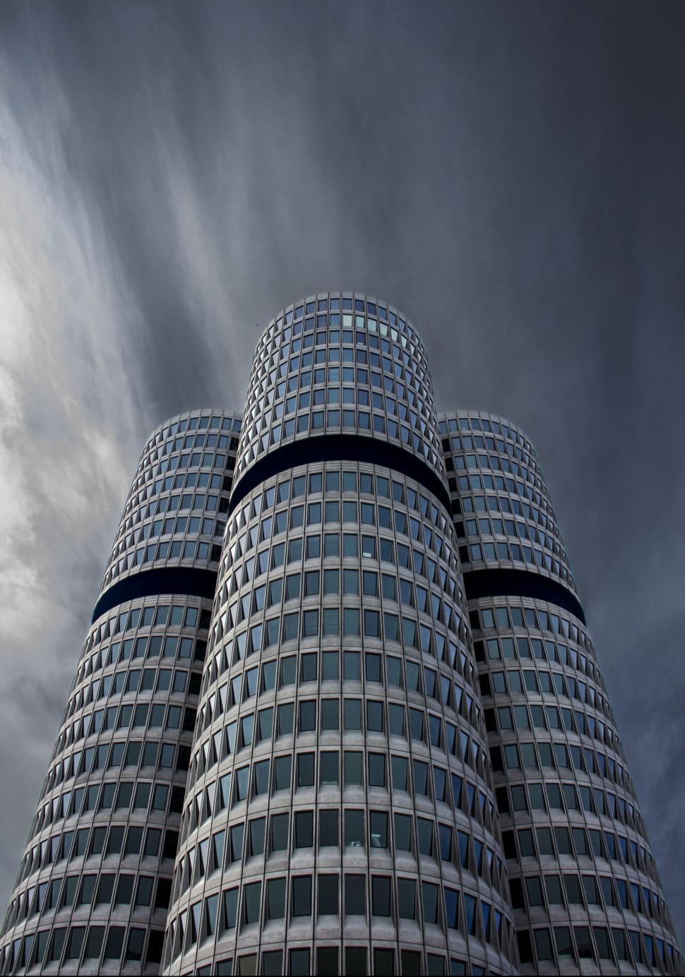Free Image of Tall Building With Many Windows Under Cloudy Sky 