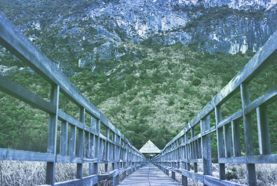 Free Image of Long Wooden Bridge With Mountain in Background 