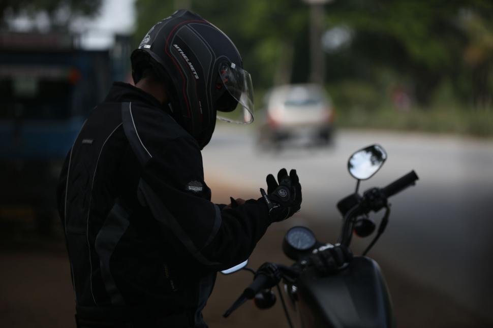 Free Image of Man in Black Jacket and Helmet Standing by Motorcycle 