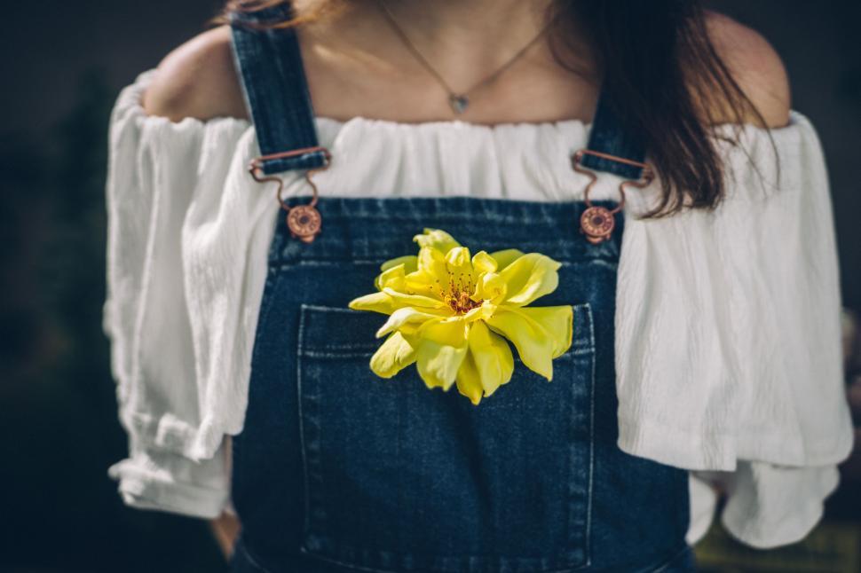 Free Image of Woman Wearing Overalls With Yellow Flower in Pocket 