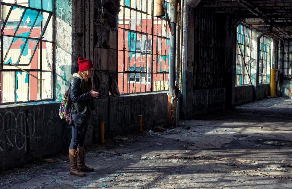 Free Image of Woman in Red Hat Standing in Abandoned Building 