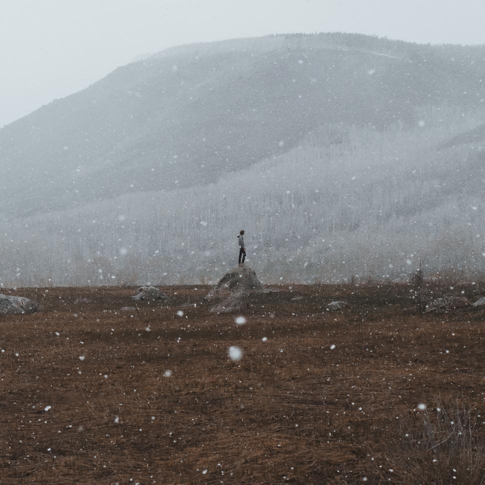 Free Image of Person Standing on Top of Snow Covered Hill 