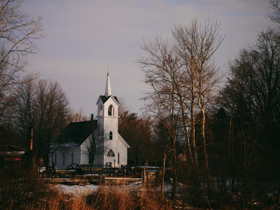 Free Image of White Church With Steeple Surrounded by Trees 