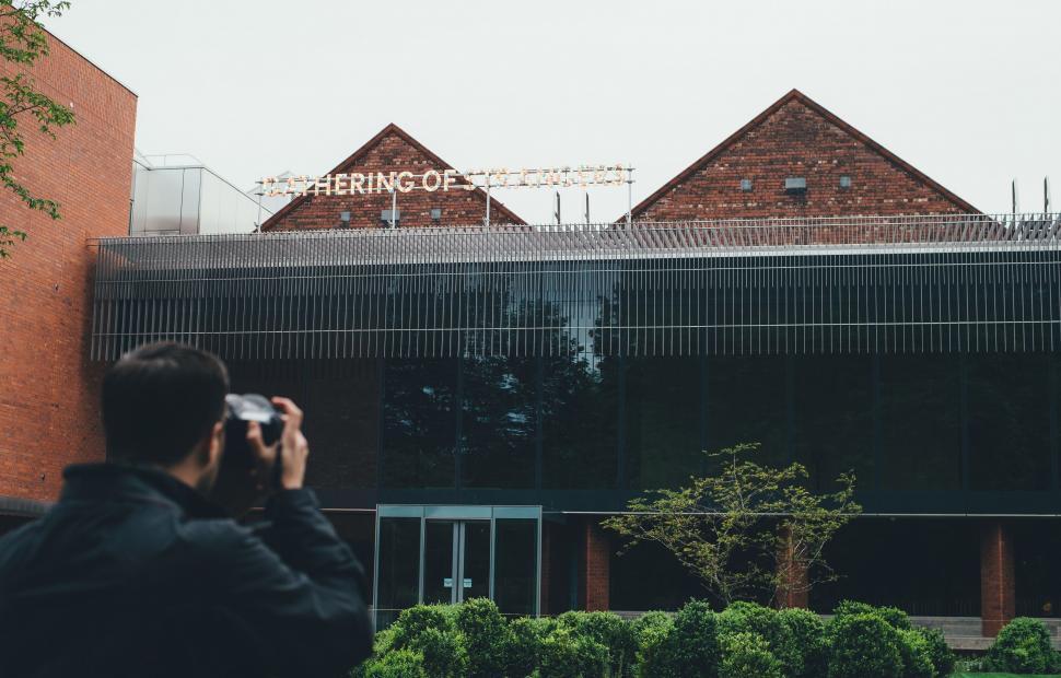 Free Image of Man Taking Picture of Building With Camera 