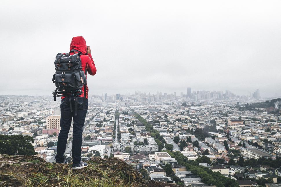 Free Image of Person With Backpack Standing on Top of Hill 