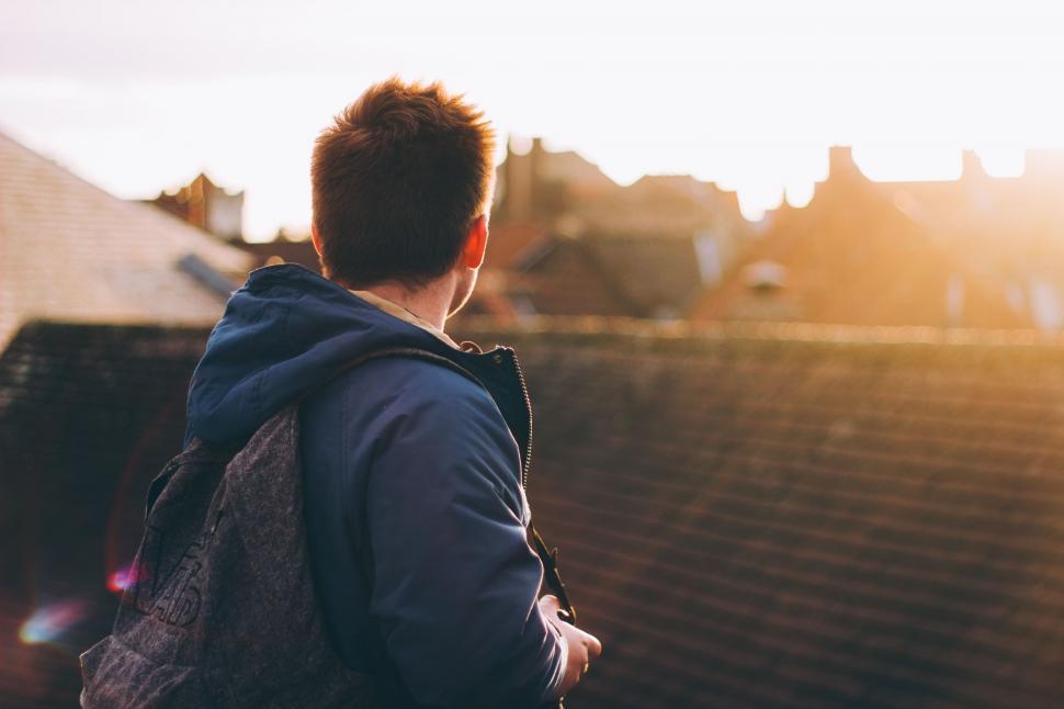 Free Image of Man Standing on Roof With Backpack 