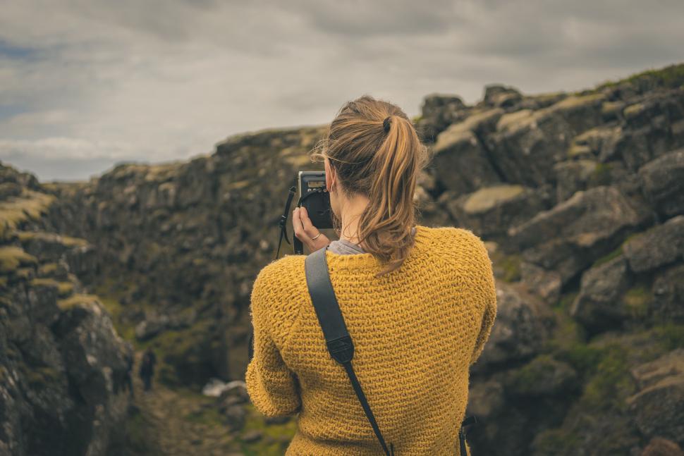 Free Image of Woman Taking Picture of Rocks With Camera 