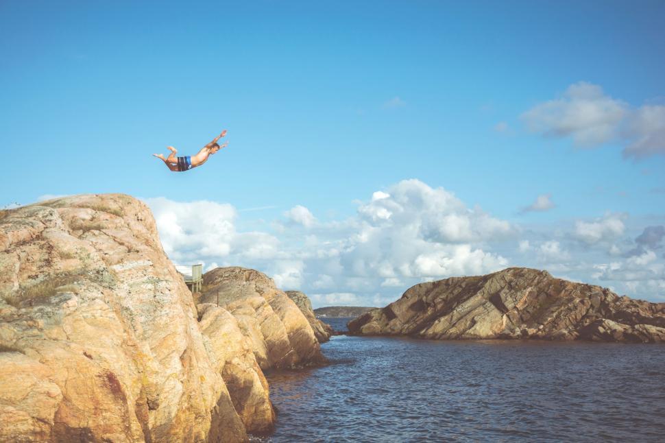 Free Image of Person Jumping off Rock Into Water 
