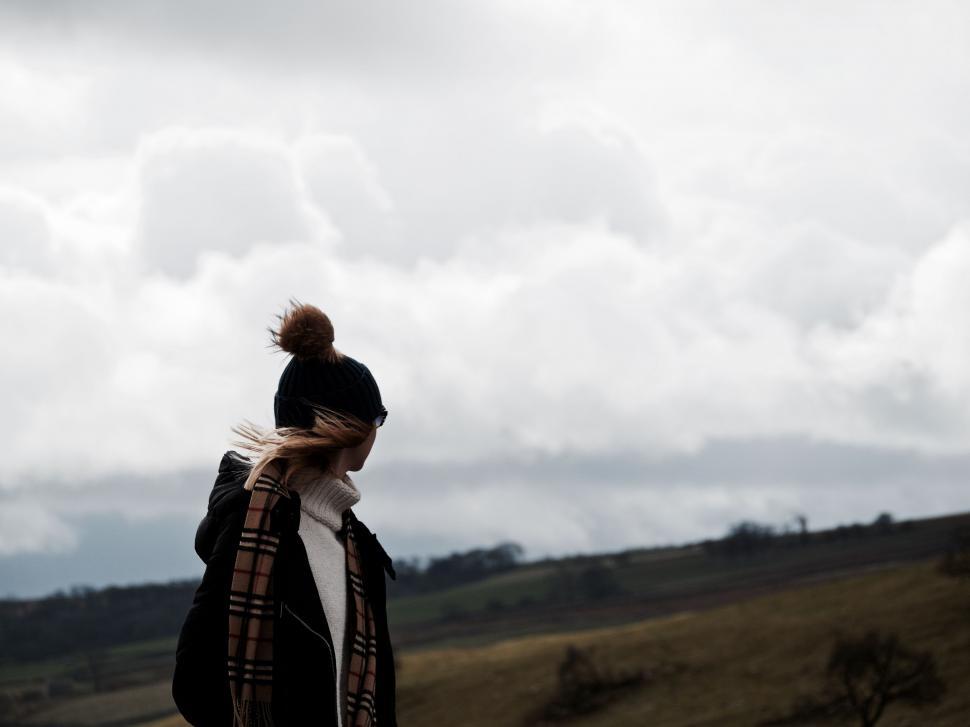 Free Image of Person Standing on Hill Under Cloudy Sky 