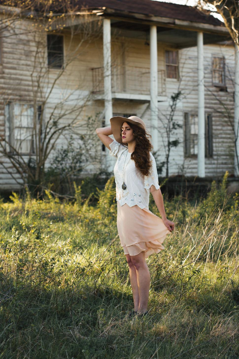 Free Image of Woman Standing in Front of Old House 