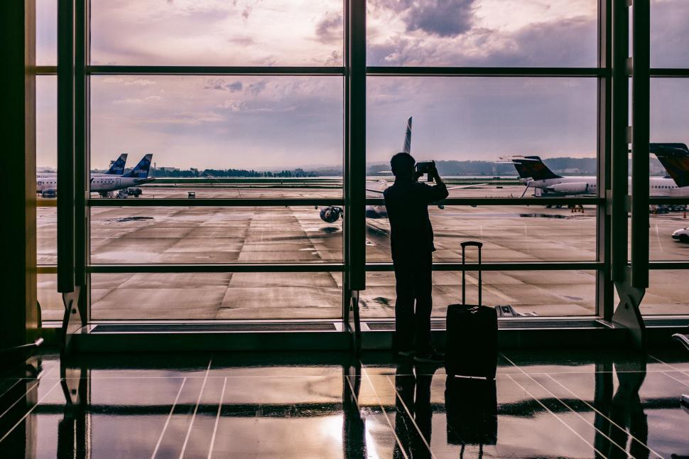 Free Image of Man Standing in Front of Airport Window 