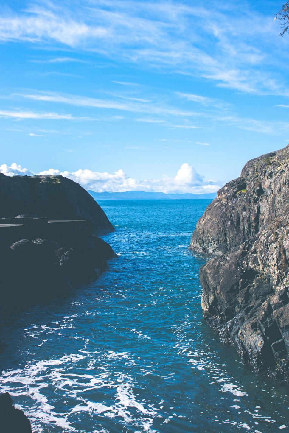 Free Image of Man Standing on Cliff Next to Ocean 