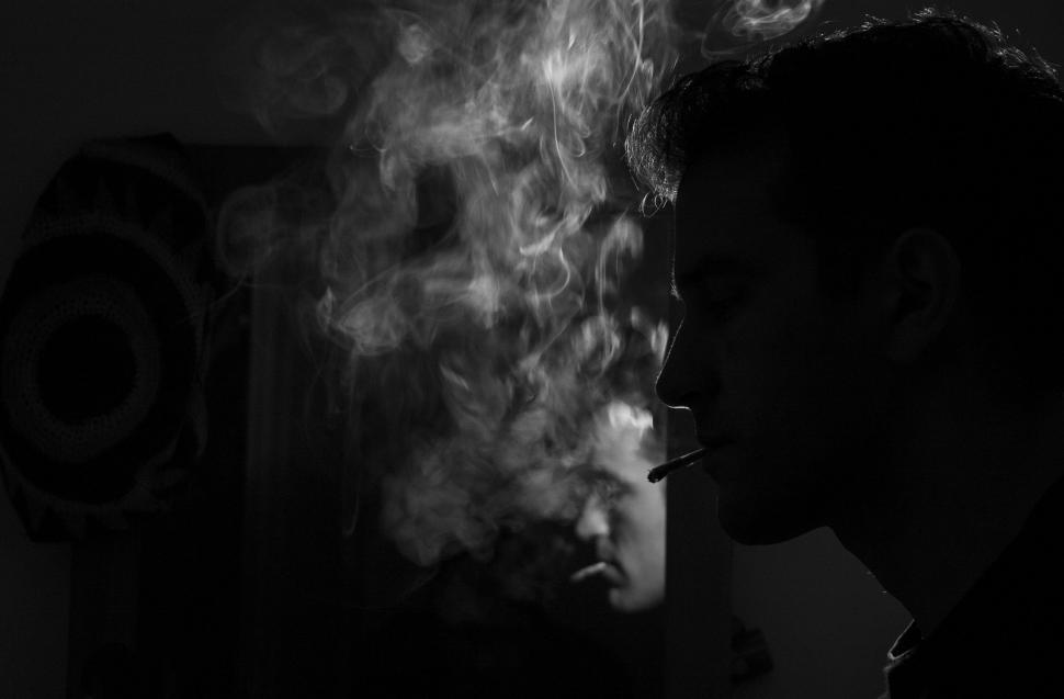 Free Image of Man Smoking a Cigarette in a Dark Room 
