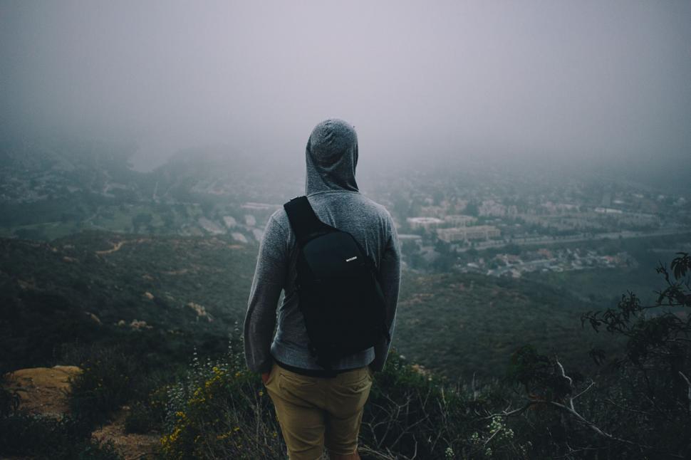 Free Image of Man Standing on Top of Hill in Fog 