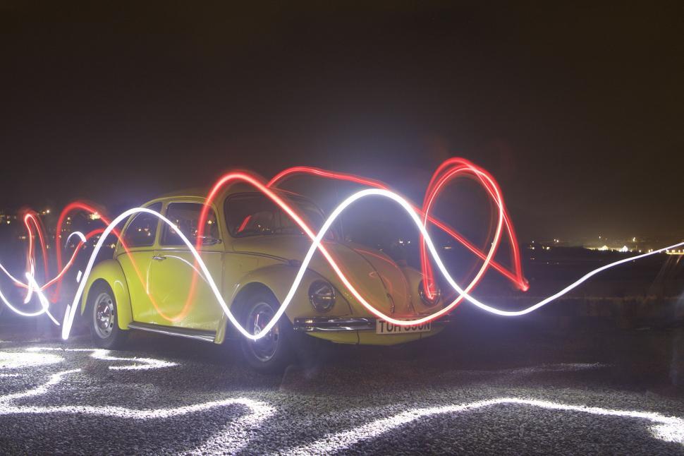 Free Image of Volkswagen Bug Driving Down Urban Street at Night 