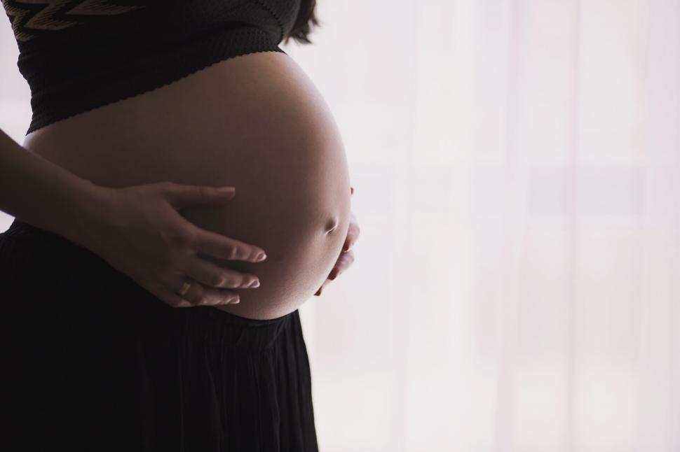 Free Image of Pregnant Woman in Black Dress Holding Belly 