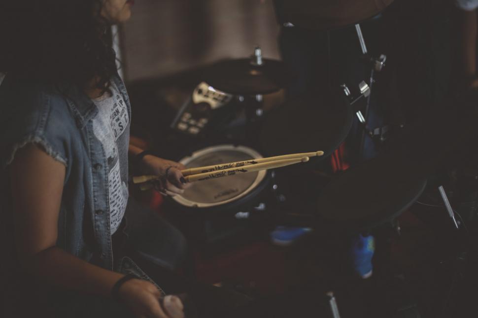 Free Image of Woman Playing Drum Set in Dark Room 
