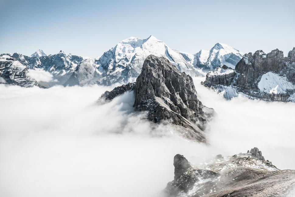Free Image of Snow-Covered Mountain Range Shrouded in Clouds 