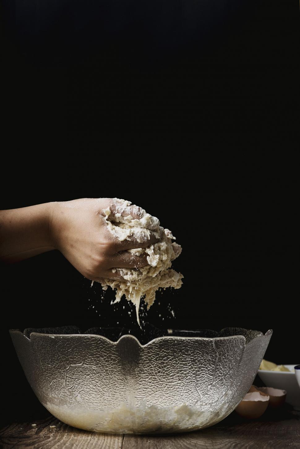Free Image of Person Sprinkling Flour Into a Bowl 