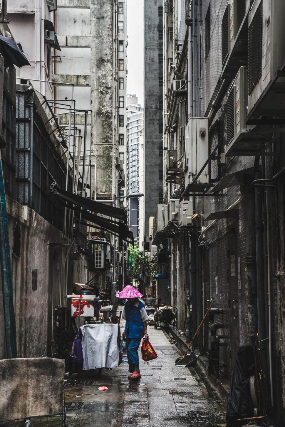 Free Image of Woman Walking Down Street Holding Umbrella 