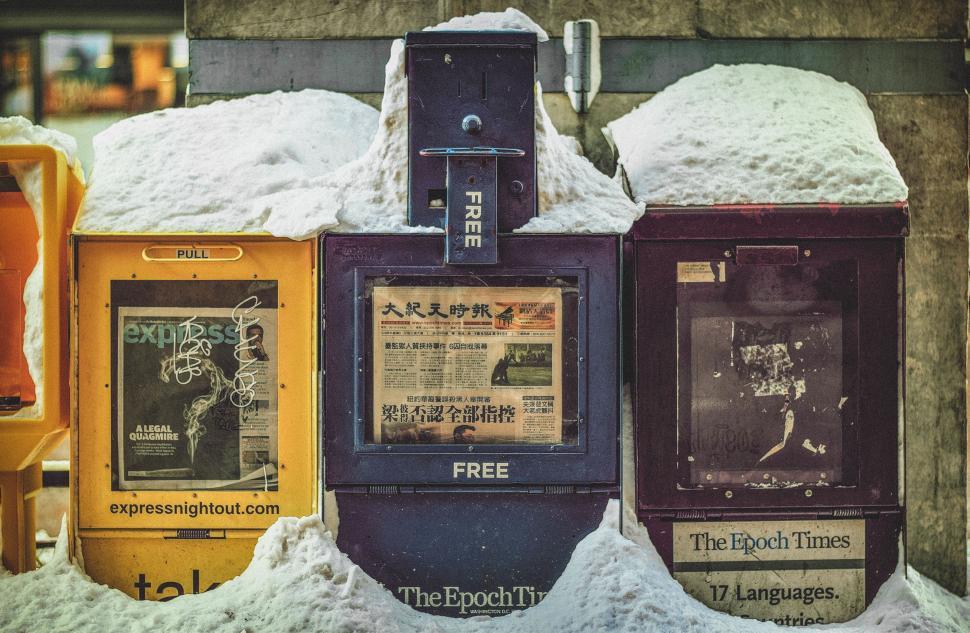 Free Image of Row of Newspaper Dispensers Covered in Snow 