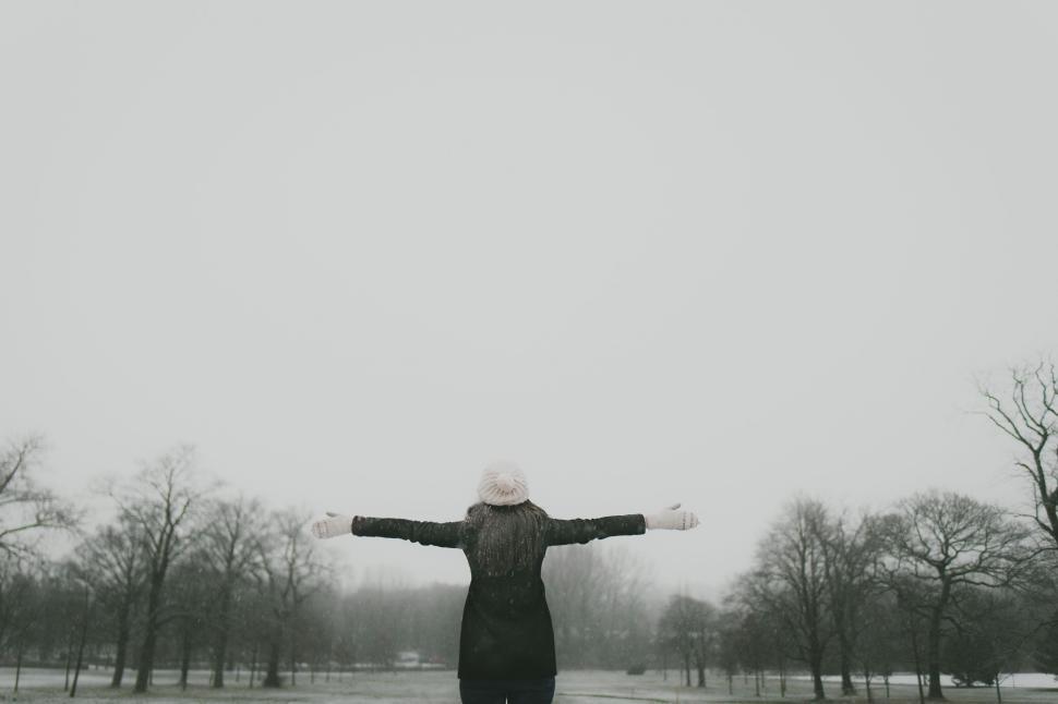 Free Image of Person Standing in Snow With Arms Outstretched 