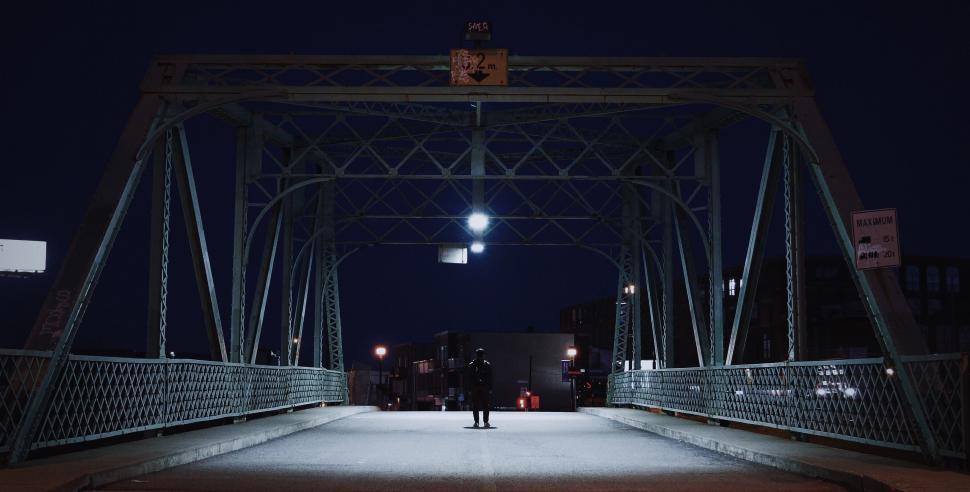 Free Image of Person Walking Across Bridge at Night 