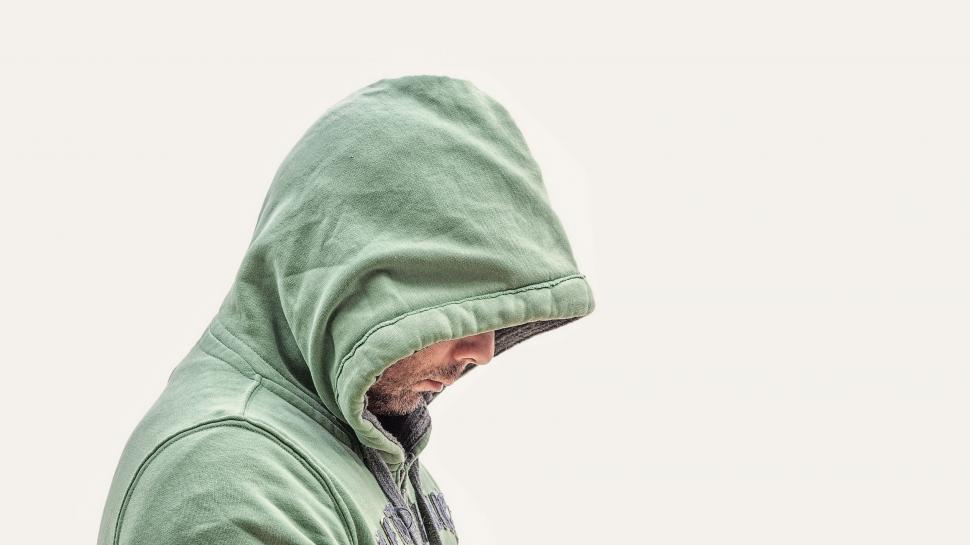 Free Image of Man in Green Hoodie Holding Cell Phone 