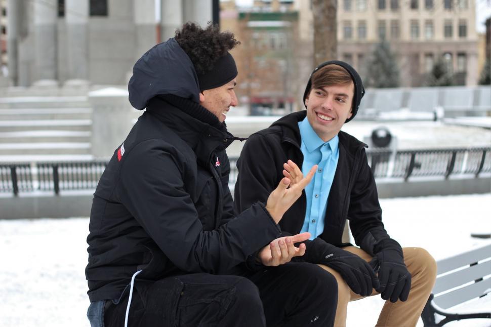 Free Image of Two People Sitting on a Bench in the Snow 