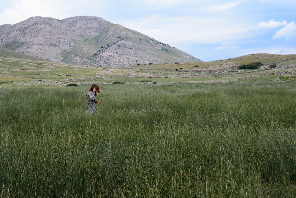 Free Image of Person Standing in Field With Mountain Background 