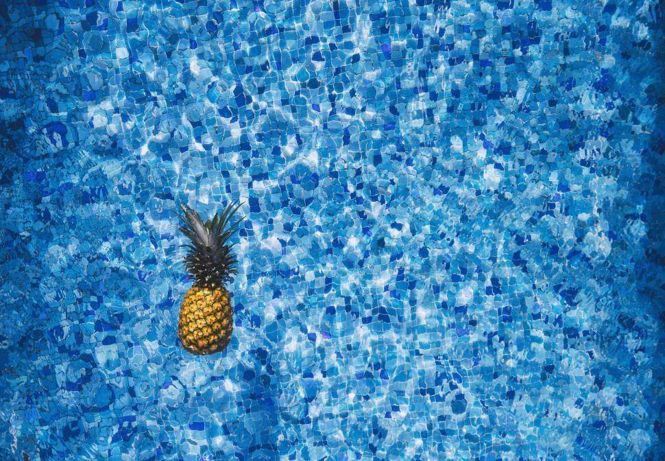 Free Image of Pineapple Resting on Blue Pool 