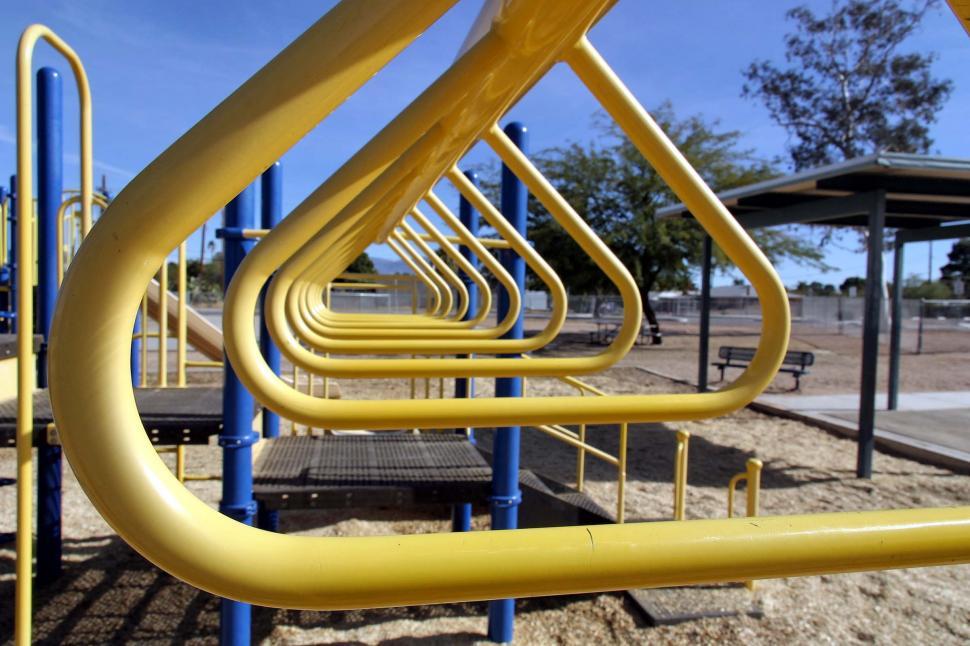 Free Image of Row of Yellow Pipes on a Playground 