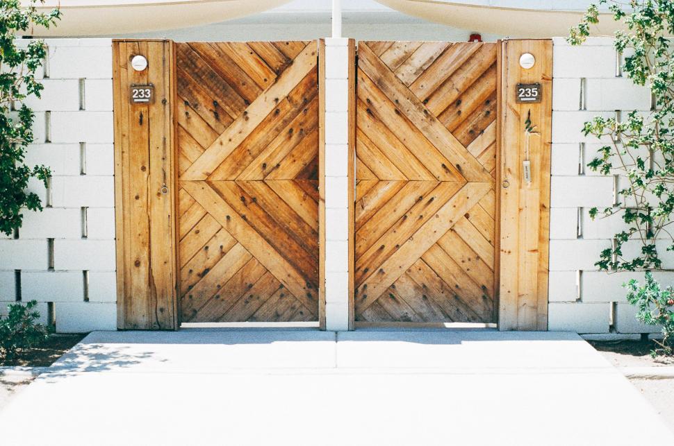 Free Image of Wooden Doors in Front of White Building 