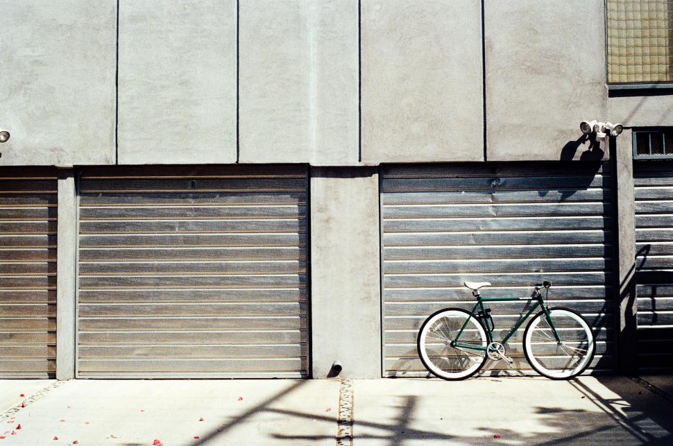 Free Image of Bicycle Parked in Front of Garage Door 
