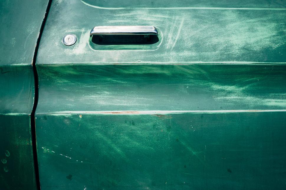 Free Image of Close Up of the Side of a Green Car 