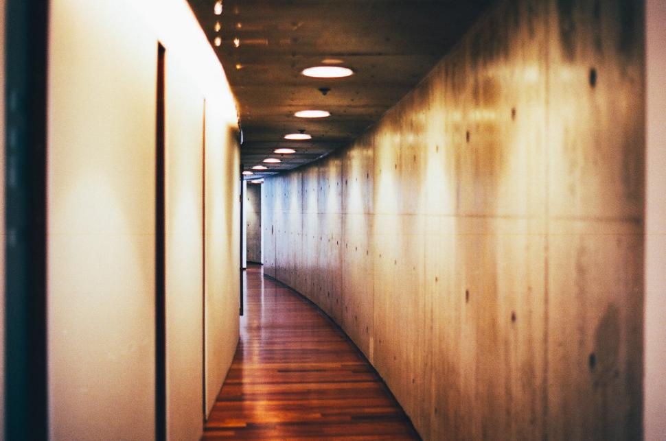 Free Image of Long Hallway With Wooden Floors and Lights 