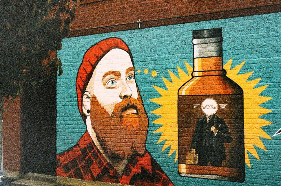 Free Image of Mural of Man With Beard Holding Liquor Bottle 