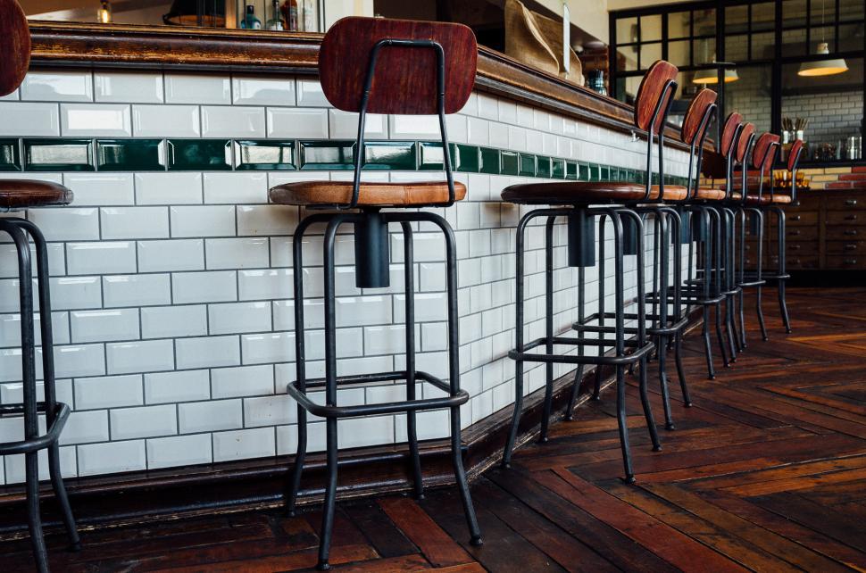 Free Image of A Row of Bar Stools in Front of a Bar 