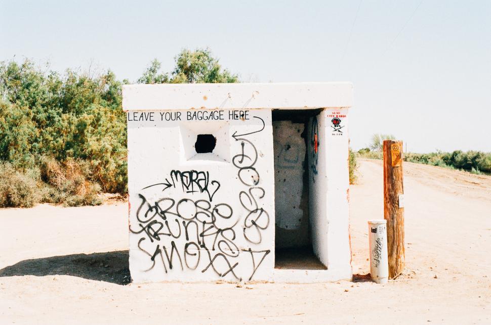 Free Image of Graffiti Covered White Outhouse 
