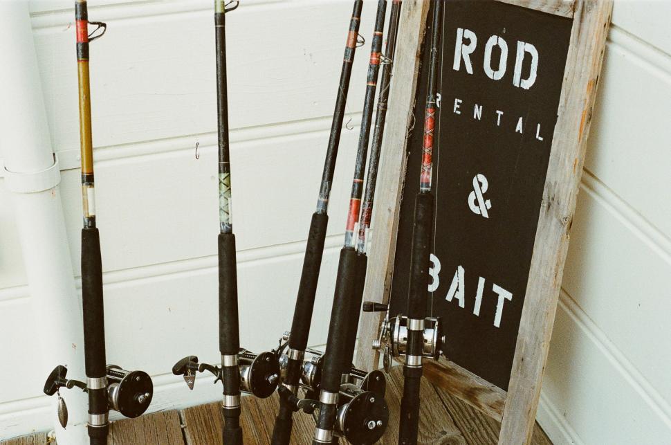 Free Image of Group of Fishing Rods Next to Sign 